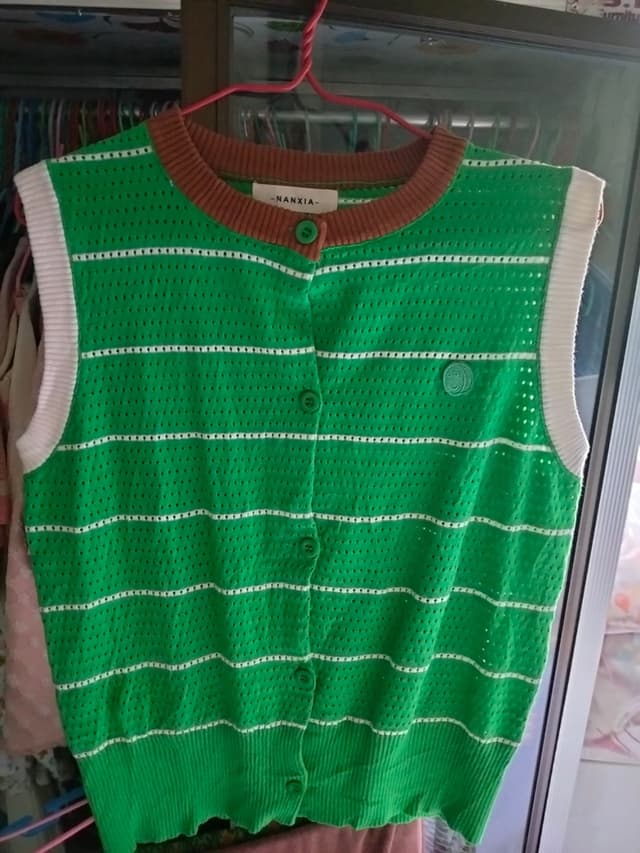 Green knitted sweater vest with white stripes