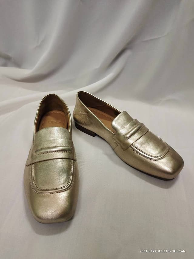 Gold UGG leather penny loafers with a rounded square toe and metallic finish